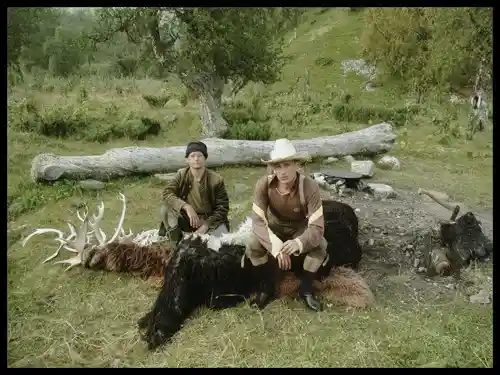 Two hunters posed with their kill in a rural Norwegian landscape, surrounded by nature.