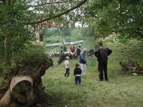 Visitors observing a large photo of hunters in a forested area at Fort Sabina, Netherlands.