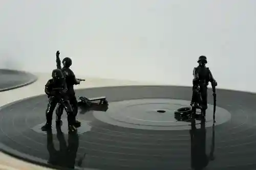 Detailed view of miniature battle figurines on a vinyl record in the Fair Game # 2 installation.