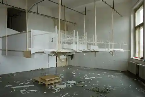 Large-scale installation of a railway station model suspended in an open workshop space.