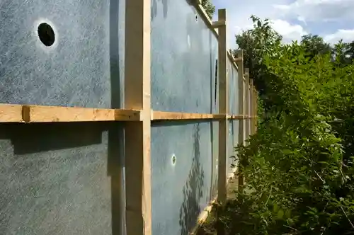 Close-up of the wooden structure and translucent panels with visible circular holes.