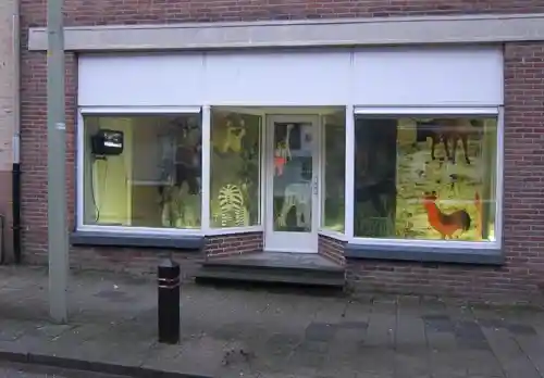 Exterior view of a storefront window showcasing an installation with animal figures at Greylight Projects.